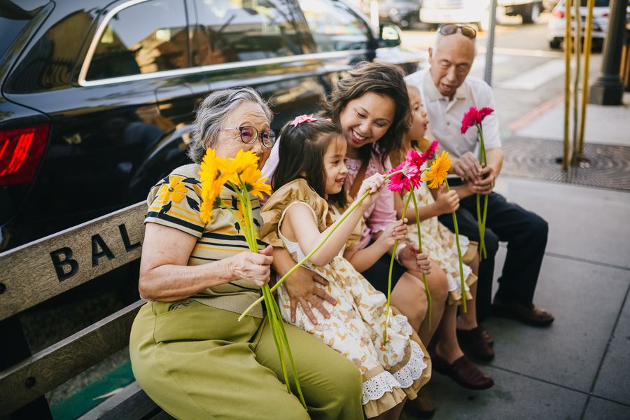 A multigenerational family sharing a bench, grandparents to grandchildren
