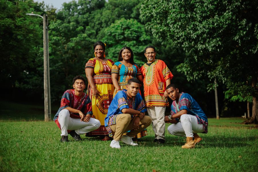 A family in traditional dress gathered together in a park